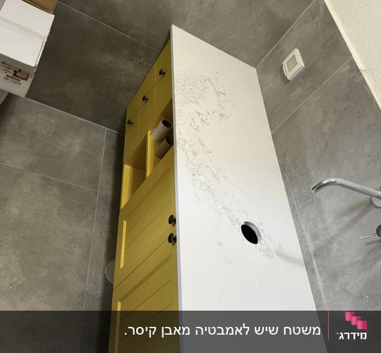 שיש לבן עם דוגמת עורקים אפורה על ארון צהוב